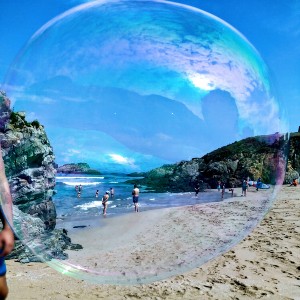 Playa con el mar y gente al fondo visto a través de una burbuja